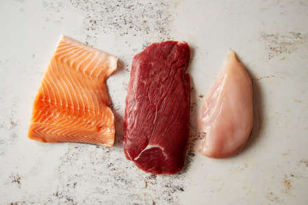 Fresh raw beef steak, chicken breast, and salmon filletの写真素材