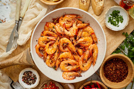 Roasted Prawns on frying pan served on white wooden cutting boardの写真素材