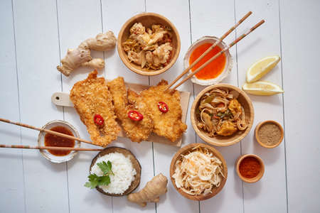 Deep fried Crispy chicken in breadcrumbs served on white wooden table with salad, spicesの写真素材