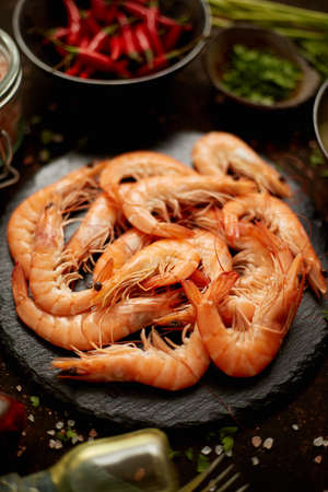 Fresh and raw big shrimps ready to be prepared. With various ingredients on sideの写真素材