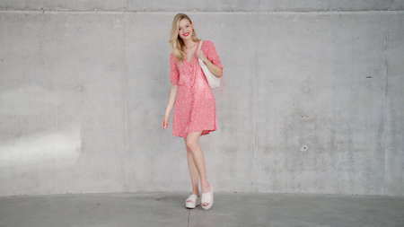 Trendy female near concrete wallの写真素材