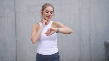 Sportswoman checking pulse during trainingの写真素材