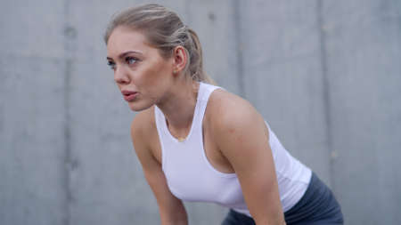 Exhausted female jogger taking breakの写真素材