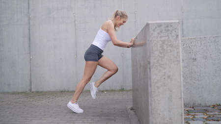 Female athlete exercising near barrierの写真素材