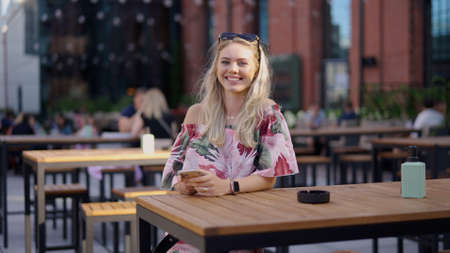 Happy female with smartphone in cafeの写真素材