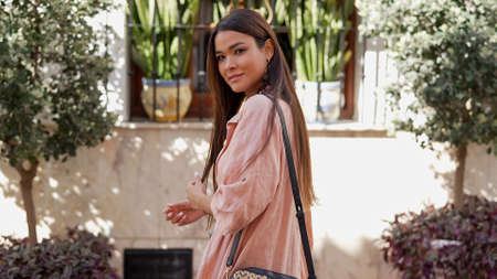 Positive ethnic woman walking on street of andalusia townの写真素材