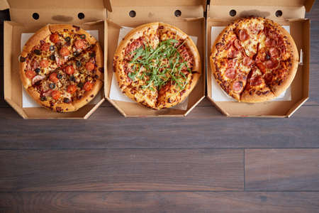 Three different kind of pizzas in delivery boxesの写真素材