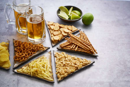 Tray with beer and snacks on tableの写真素材