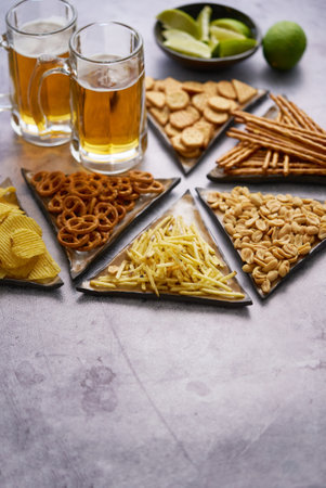 Assorted snacks with beer on tableの写真素材