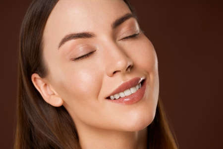Smiling woman with natural makeup and eyes closedの写真素材