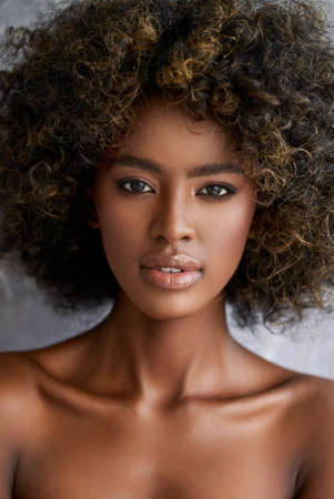 Black woman with curly hair looking at cameraの写真素材