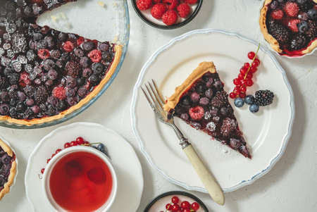 Sweet dessert with fresh baked forest fruit pie served with raspberry teaの写真素材