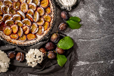 Homemade pie with plums on the table on a white stone backgroundの写真素材