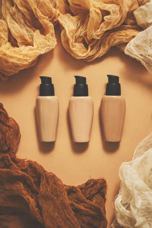 Bottles of three different shades of makeup foundation on beigeの写真素材