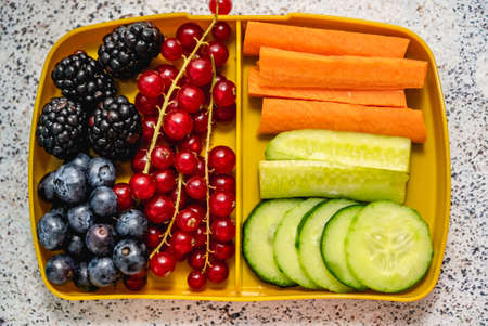 Healthy school lunch box with fresh vegetables and fruitsの写真素材