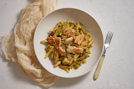 A delicious grilled chicken and pasta dumplings with pesto. Dinner on a white plateの写真素材