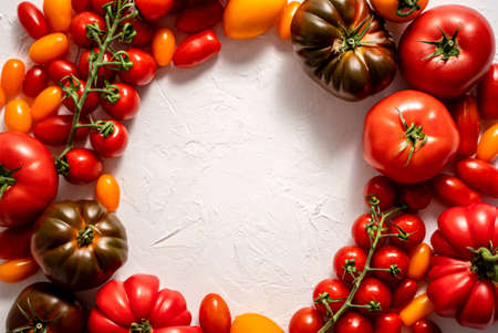 Tomatoes on the table. Tomatoes of different varieties. Circular composition with copy spaceの写真素材