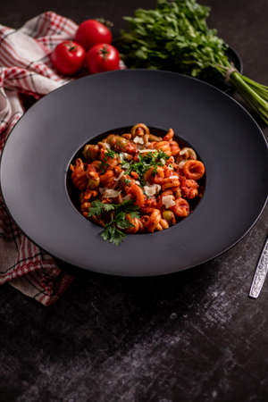 Tasty appetizing classic italian pasta with tomato sauce, cheese parmesan and basil on plateの写真素材