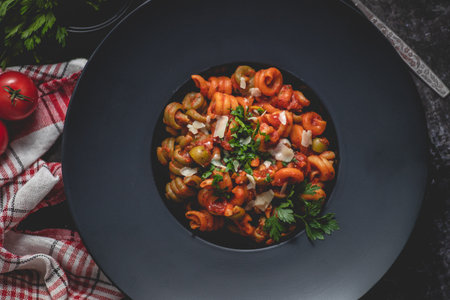 Tasty appetizing classic italian pasta with tomato sauce, cheese parmesan and basil on plateの写真素材