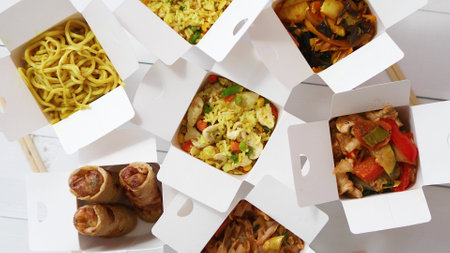 Take away food concept. Spring rolls, fried rice with chicken, curry and wok noodlesの写真素材