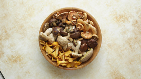 Various kinds of assorted raw mushrooms placed in wooden bowlの写真素材