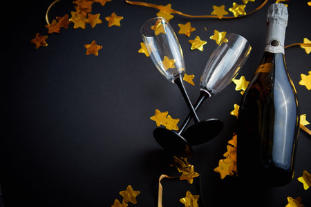 Glasses and bottle of champagne with golden serpentines and confettiの写真素材