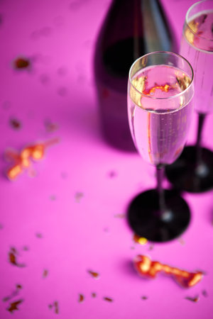 Two glasses full of sparkling champagne wine with golden decorationの写真素材