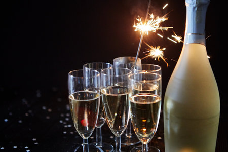 Party composition image. Glasses filled with champagne placed on black tableの写真素材