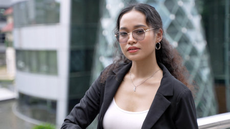 Portrait of asian businesswoman standing outside of office buildingの写真素材