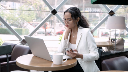 Professional Woman Working Remotely with Wireless Technology in a Cozy Cafeの写真素材