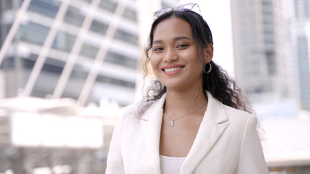 Thai Businesswoman Smiling in Front of Bangkok Skyscrapersの写真素材