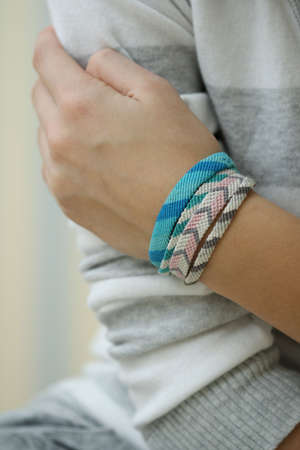 Hand of girl with four handmade braceletの写真素材