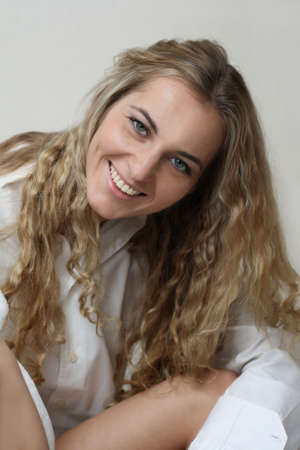 Young blonde beautiful girl portrait in white smiling