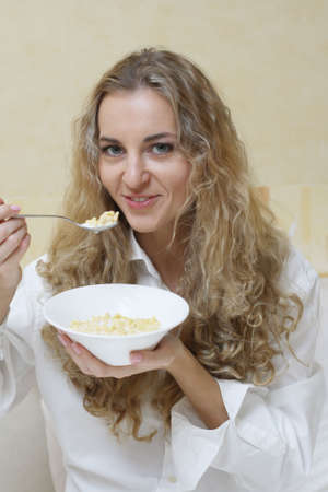 Young beautiful woman eating corn flakes