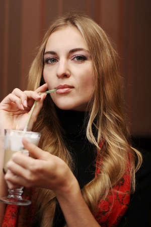 The girl drinks coffee latte in the cafe