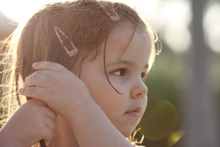 Little girl making her wet hair in the sunshineの写真素材