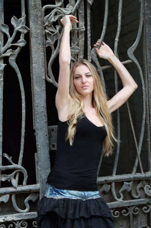 Young attractive blond girl near the park fenceの写真素材