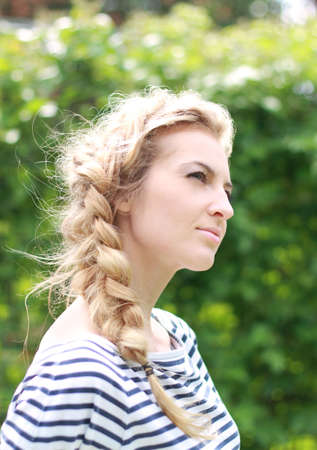 Young attractive blond girl in the gardenの写真素材