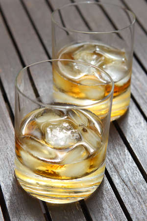 Close-up of a two glasses of whiskey on the wooden table の写真素材