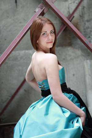 Romantic girl in the beautiful dress near the old wallの写真素材