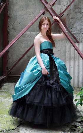 Romantic girl in the beautiful dress near the old wallの写真素材