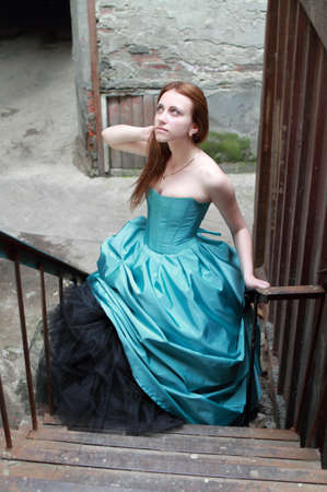Romantic girl in the beautiful dress on the stairsの写真素材