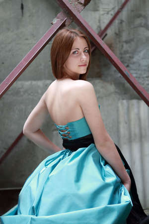 Romantic girl in the beautiful dress near the old wallの写真素材