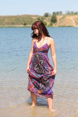 Happy brunette girl on the summer lakeの写真素材