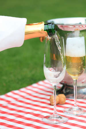 Champagne being poured to glasses at a summer picnicの写真素材