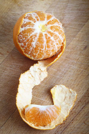 Tangerine with peeled on the wooden backgroundの写真素材