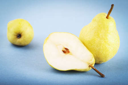 Three yellow pears on the blue backgroundの写真素材