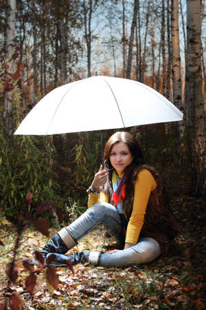 Brunette girl in the forest under light umbrellaの写真素材
