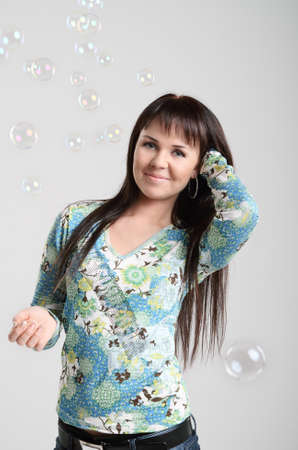 Smiling brunette girl and soap bubblesの写真素材