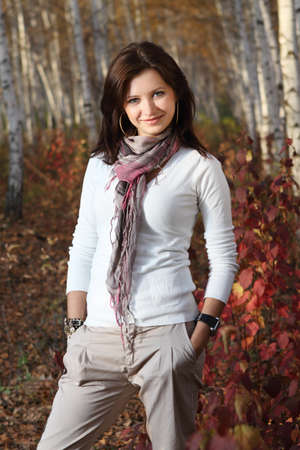 Beautiful smiling brunette girl in autumn forestの写真素材
